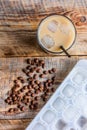 Coffee break with cold iced latte and beans on wooden table background top view Royalty Free Stock Photo