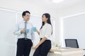 Coffee break. Couple of young colleagues in formal wear standing Royalty Free Stock Photo