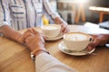 Coffee, break and dating couple holding hands on a romantic date at a cafe, restaurant or coffee shop. Man, woman or Royalty Free Stock Photo