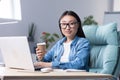 Coffee break in the office. Young beautiful Asian business woman drinking coffee at a desk Royalty Free Stock Photo