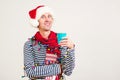 Coffee break for Santa helper. Copy space for text. Smiling man in Santa Claus hat holding a paper cup of coffee