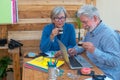 Coffee break on the terrace for a retired couple of people, man and woman with white hair. Sitting outdoor at a wooden table Royalty Free Stock Photo