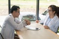 Two doctors meeting and talking in cafÃÂ©. Man doctor looking at his watch in coffee shop Royalty Free Stock Photo