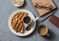 Coffee break in the workplace. Coffee and viennese waffles with chocolate sauce on a gray background