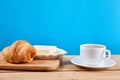 Coffee breakfast with croissant, butter and cup of black coffee on a oak wooden table Royalty Free Stock Photo