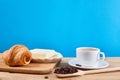 Coffee breakfast with croissant, butter and cup of black coffee on a oak wooden table Royalty Free Stock Photo