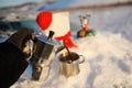 Coffee brewing in moka pot on a gas burner on the car trunk outdoor in winter snow landscape