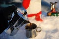 Coffee brewing in moka pot on a gas burner on the car trunk outdoor in winter snow landscape