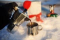 Coffee brewing in moka pot on a gas burner on the car trunk outdoor in winter snow landscape