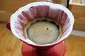 Coffee brewing in a paper filter in a red dripper, close-up, top view. Pour over method Royalty Free Stock Photo
