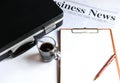 Coffee and briefcase with notebook on newpaper. Royalty Free Stock Photo