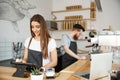 Coffee Business Concept - beautiful caucasian bartender barista or manager Posting order in digital tablet menu at