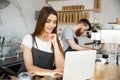 Coffee Business Concept - beautiful caucasian bartender barista or manager working and planing in laptop at modern Royalty Free Stock Photo