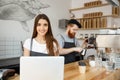 Coffee Business Concept - beautiful caucasian bartender barista or manager working and planing in laptop at modern Royalty Free Stock Photo