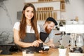 Coffee Business Concept - Beautiful female barista giving payment service for customer with credit card and smiling Royalty Free Stock Photo