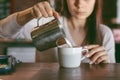 Coffee Business Concept - close-up lady barista in apron preparing and pouring milk Royalty Free Stock Photo