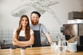 Coffee Business Concept - Positive young bearded man and beautiful attractive lady barista couple enjoy working together Royalty Free Stock Photo