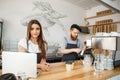 Coffee Business Concept - Positive young bearded man and beautiful attractive lady barista couple enjoy working together Royalty Free Stock Photo