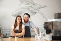 Coffee Business Concept - Positive young bearded man and beautiful attractive lady barista couple enjoy working together Royalty Free Stock Photo