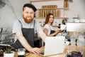 Coffee Business Concept - Young handsome bearded bartende, barista or manager working and planing in laptop at modern Royalty Free Stock Photo