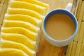 Coffee and butter slice of bread on wooden chop block