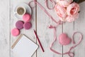 Coffee, cake macaron, clean notebook, eyeglasses and flower on pink table from above. Female working desk. Cozy breakfast. Flat la Royalty Free Stock Photo