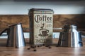 Coffee canister surrounded by a Bialetti and some coffee beans