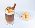 Coffee, cappuccino in a glass, Irish glass. Whipped cream sprinkled with ground nuts and chocolate chips, a cinnamon stick. Glass