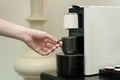 Coffee capsule machine maker. Hand takes a ceramic cup of coffee on the coffee machine Royalty Free Stock Photo