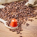 Coffee capsule on wooden spoon and coffee beans Royalty Free Stock Photo