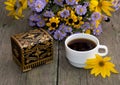 coffee, casket and bouquet of beautiful wild flowers, on a wooden table Royalty Free Stock Photo