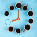 Coffee clocks. Different cups on the blue background with clock hands. Flatlay, time concept