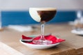 Coffee cocktail with green paste in wine glass on red napkin and plate Royalty Free Stock Photo