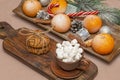 Coffee or cocoa with marshmallows on a long vintage board in a Christmas composition. Oatmeal cookies and tangerines with sweets