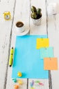 coffee, colorful cards with space for text, a yellow alarm clock next to the crumpled balls of paper. Office concept, Light woode Royalty Free Stock Photo