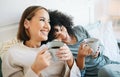 Coffee, communication and happy lesbian couple on bed bonding and relaxing together. Happy, rest and young interracial Royalty Free Stock Photo