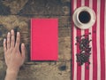 Coffee concept with cup, a male hand and a book Royalty Free Stock Photo