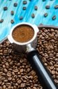 Coffee cone and ground coffee on coffee beans and on a ceramic plate