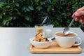 Stirring coffee on white table and cookies at side, garden atmosphere. Royalty Free Stock Photo