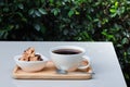 Coffee and cookie on wood tray on white table in the garden atmosphere. Royalty Free Stock Photo