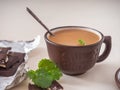 Coffee with cream and mint in a brown ceramic mug, a sprig of mint and chocolate Royalty Free Stock Photo