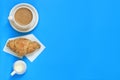 Coffee and croissant on a blue background. Flat lay, top view. Copy space Royalty Free Stock Photo