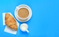 Coffee and croissant on a blue background. French breakfast Royalty Free Stock Photo