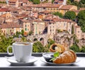 Coffee with croissants against Moustiers Sainte Marie village in Provence, France Royalty Free Stock Photo