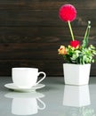 Coffee cup and Artificial flower vase bouquet over table Royalty Free Stock Photo