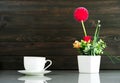 Coffee cup and Artificial flower vase bouquet over table Royalty Free Stock Photo