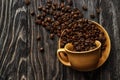 A coffee cup with coffee beans on an old wooden table. Fried coffee beans on a wooden background. Viewing from above Royalty Free Stock Photo