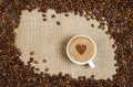 Coffee cup and beans on sacking background Royalty Free Stock Photo