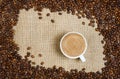 Coffee cup and beans on sacking background Royalty Free Stock Photo