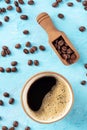 Coffee cup and beans in a scoop, shot from above on a blue background Royalty Free Stock Photo